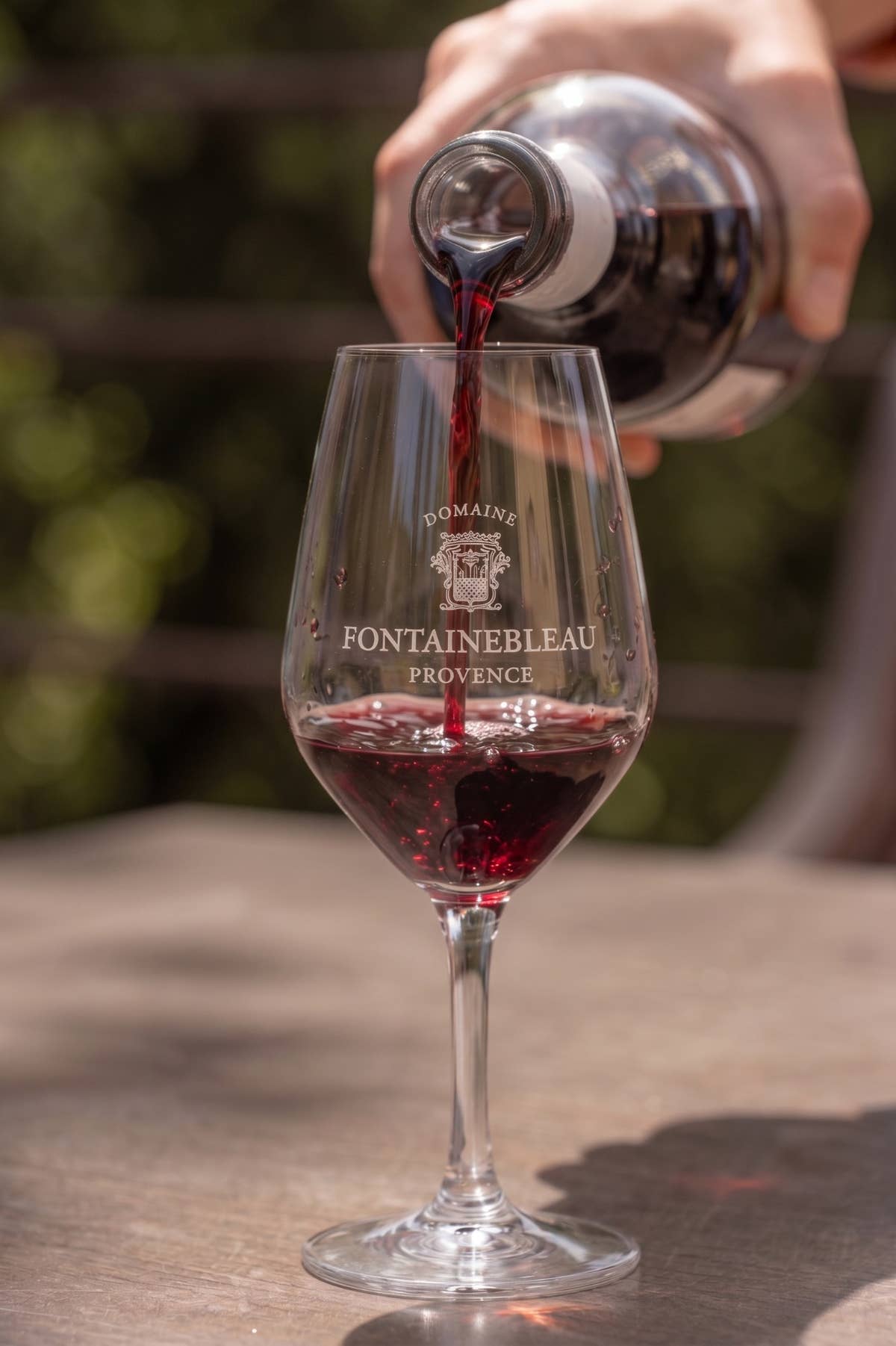 Red wine served in a glass engraved “Domaine Fontainebleau Provence”