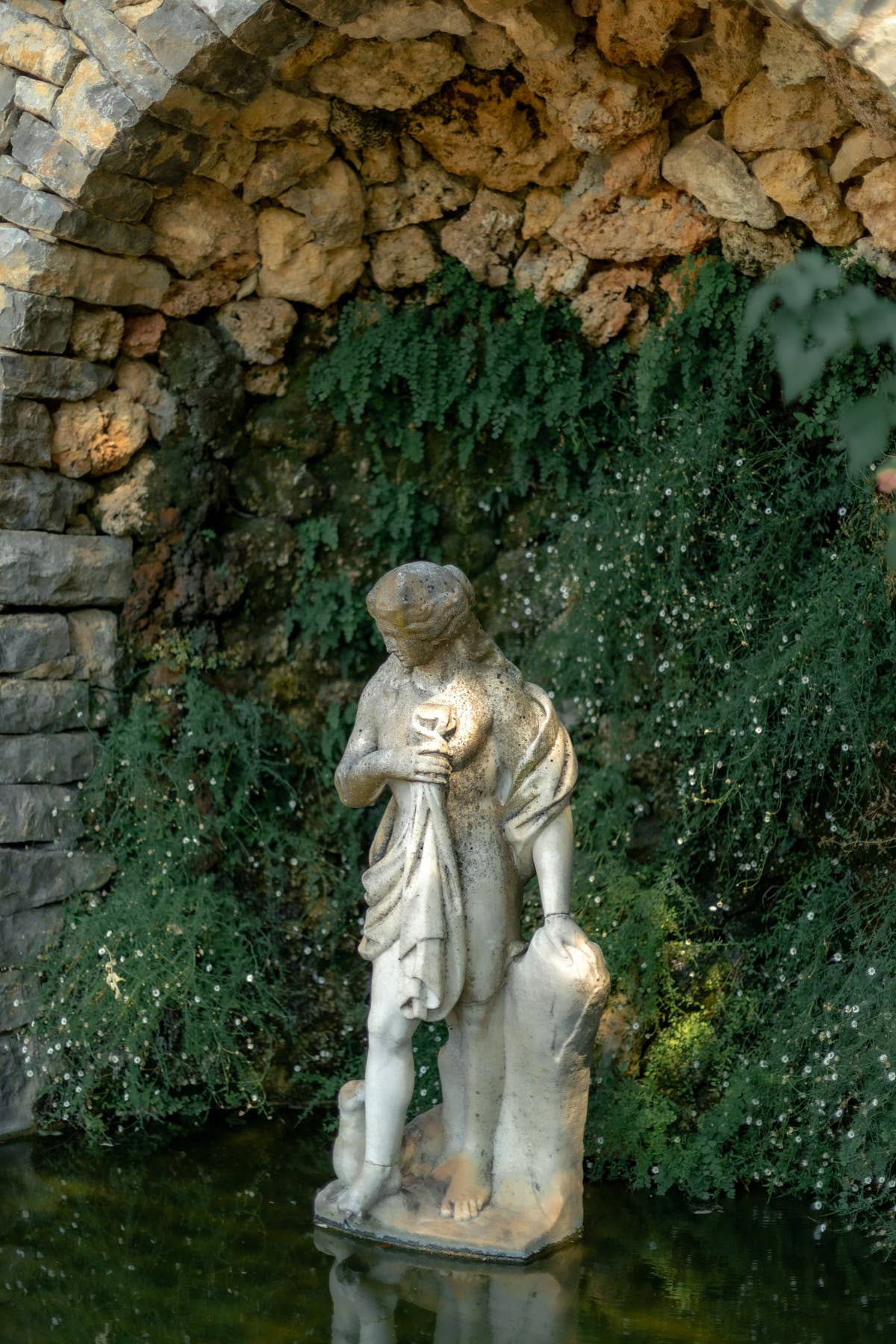 Statue dans une grotte de pierre, au bord de l’eau — Domaine Fontainebleau en Provence