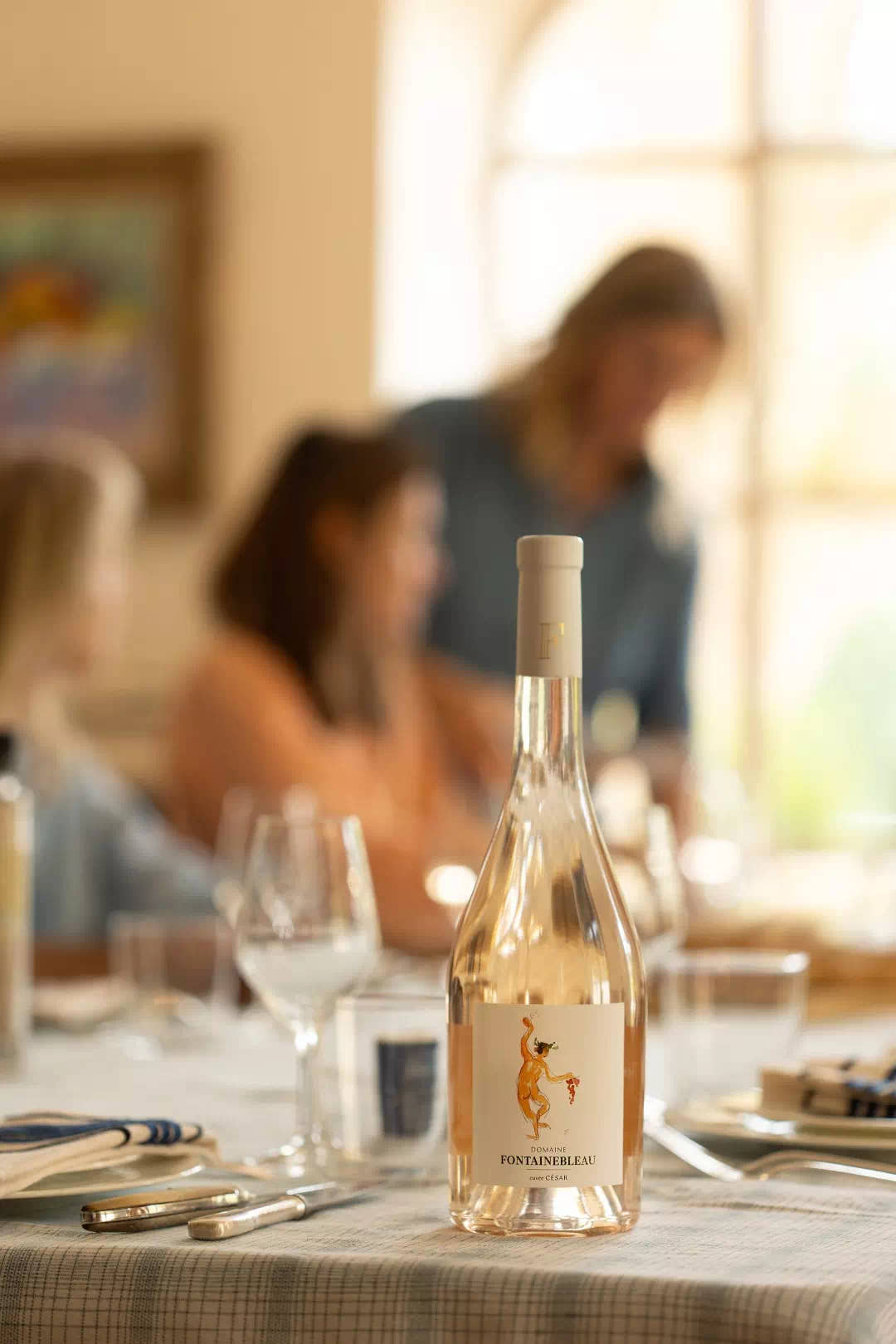 César Rosé 2025 on a laid table, guests in the background