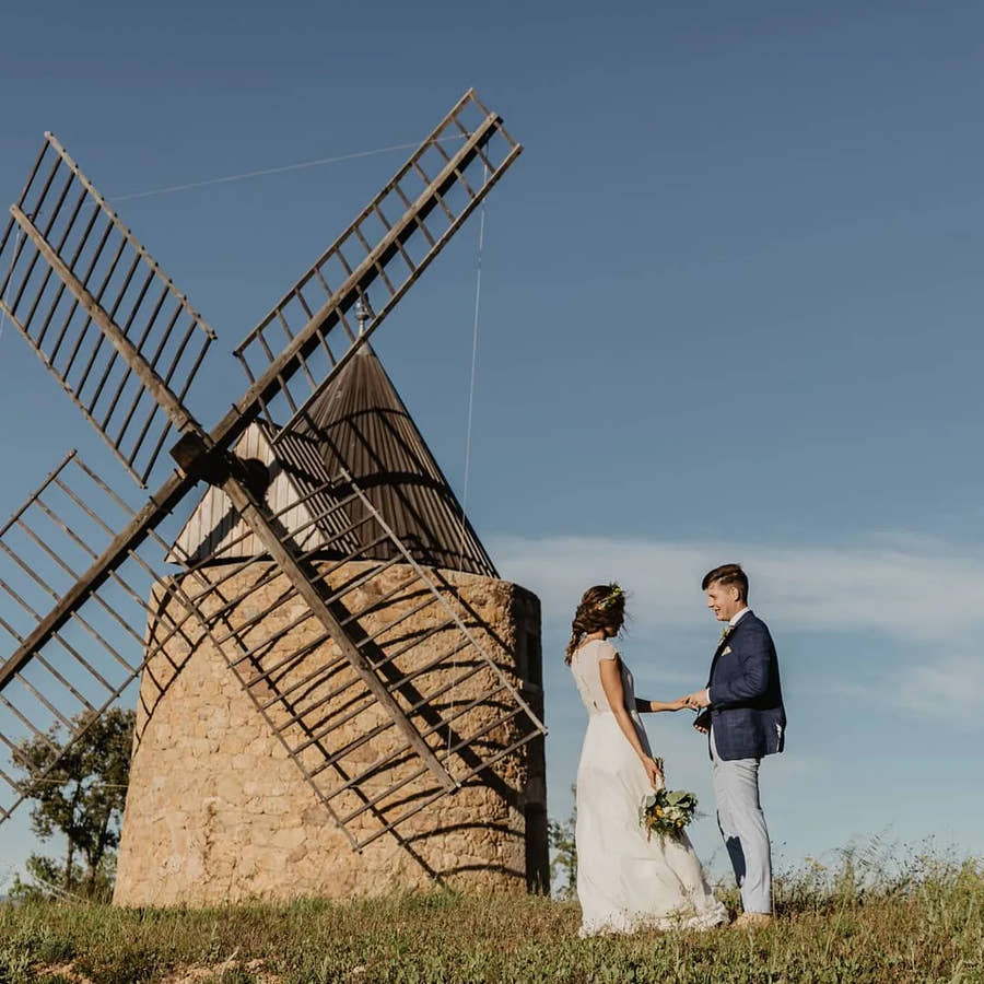 The bride and groom by the windmill — Domaine Fontainebleau en Provence
