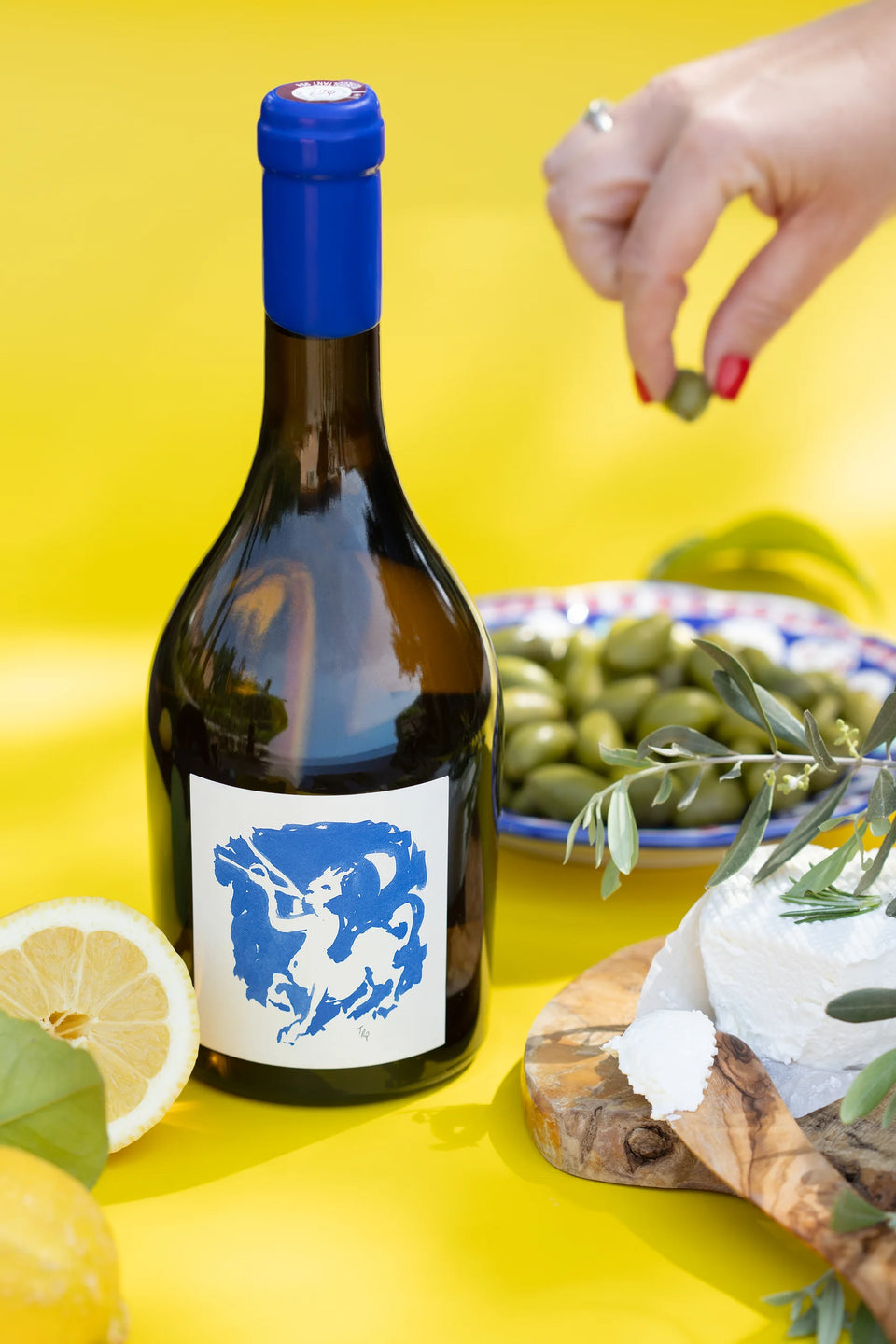 Une bouteille de la collection Insolite avec olives et citron sur fond jaune — Domaine Fontainebleau en Provence
