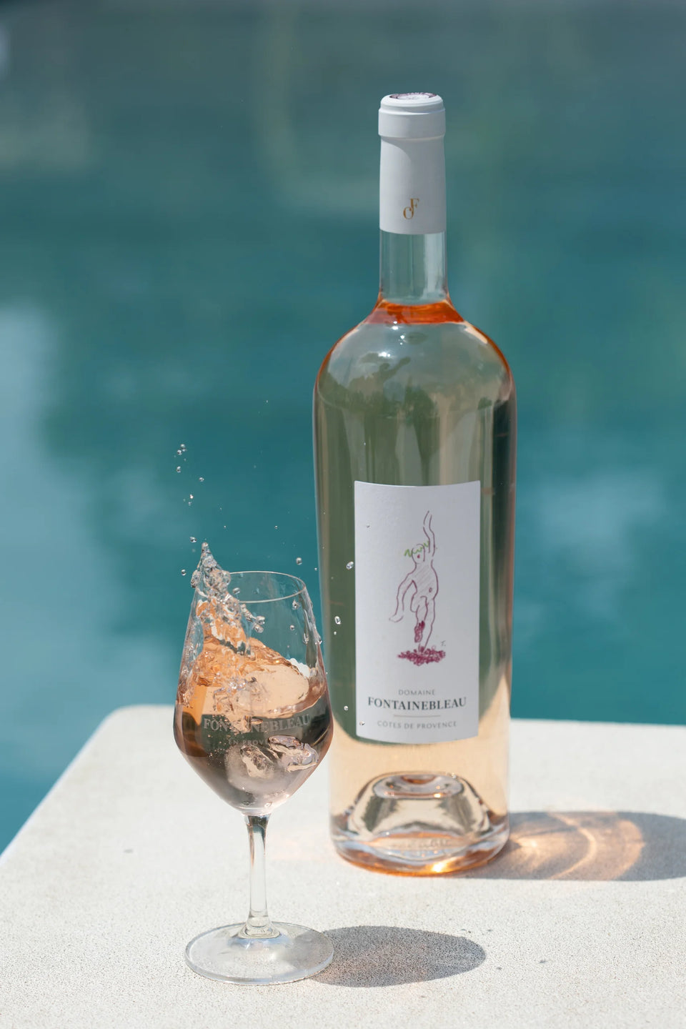 Un verre et une bouteille de rosé de la collection Provence au bord de la piscine — Domaine Fontainebleau en Provence