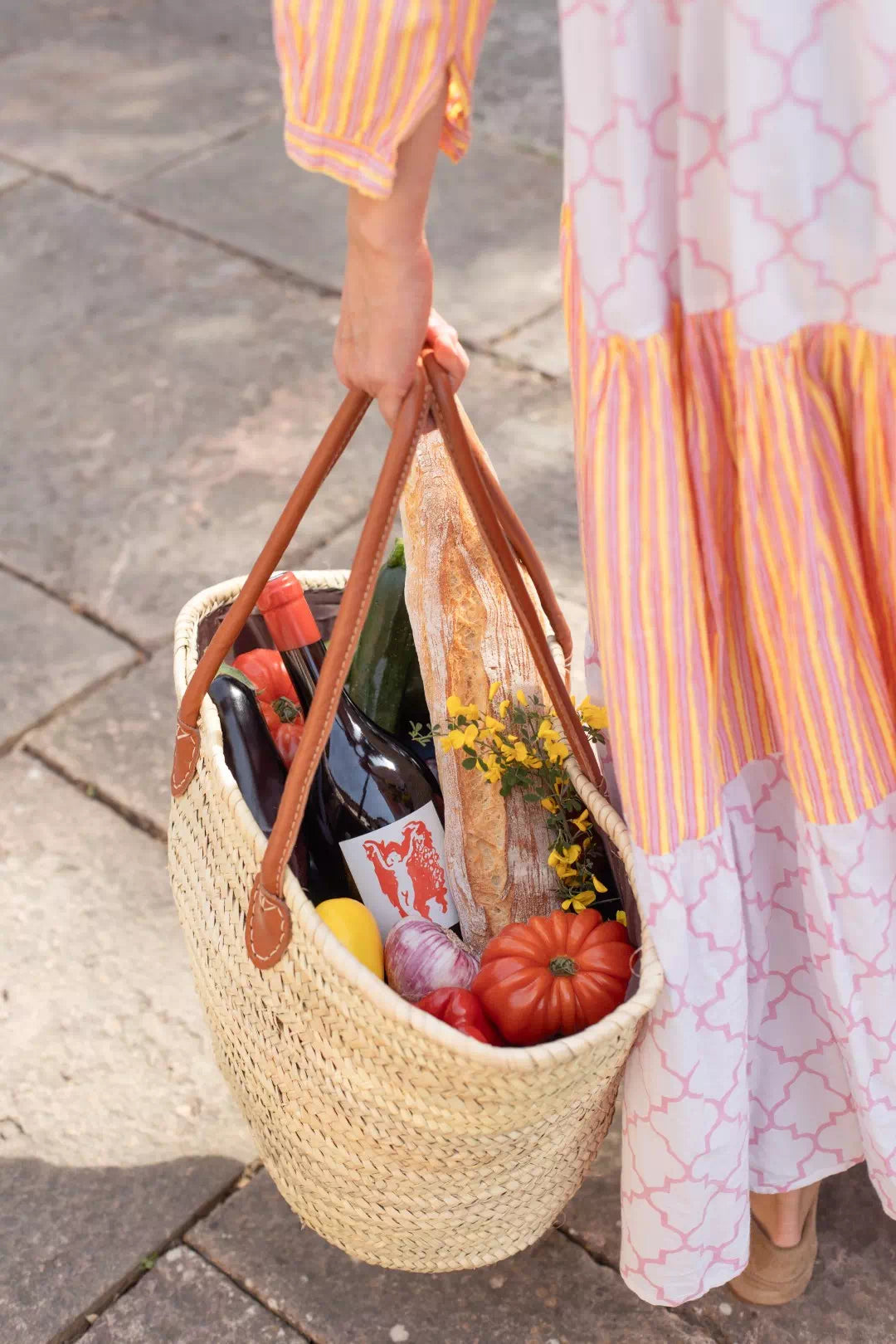 Un panier de marché porté à la main, une bouteille de Terrubi parmi les légumes